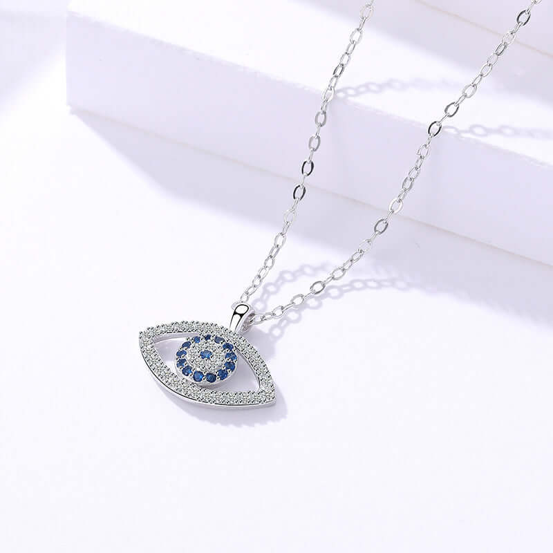 Silver necklace with an eye-shaped pendant featuring blue stones on a white background
