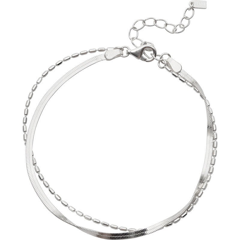 Silver bracelet with a double chain link design on a white background