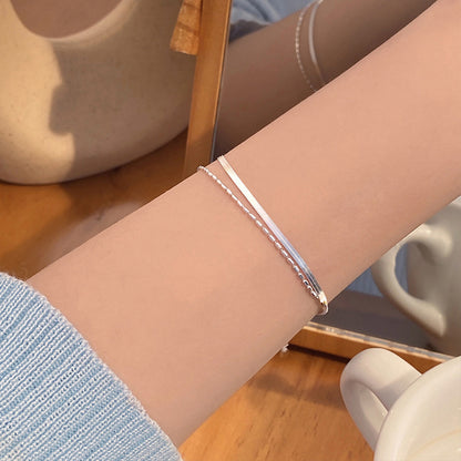 Silver Double Layer Snake Chain bracelet on a wrist with a blurred background