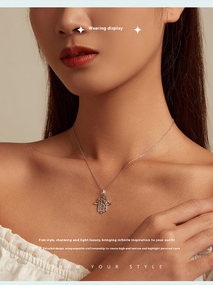 Silver necklace with a Fatima hand pendant worn by a model against a neutral background