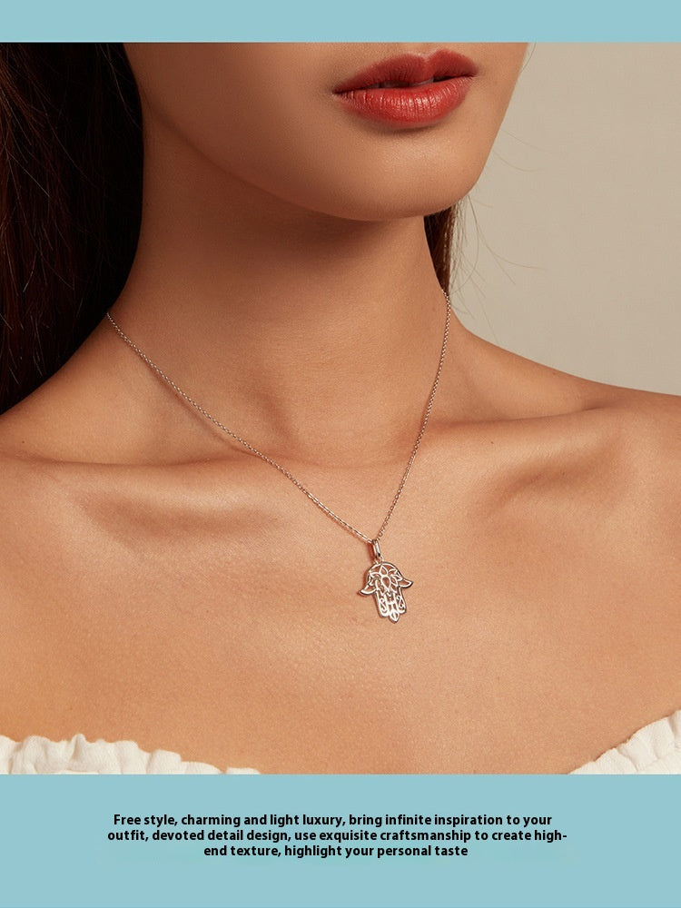 Necklace with a Fatima hand pendant worn by a model on a neutral background