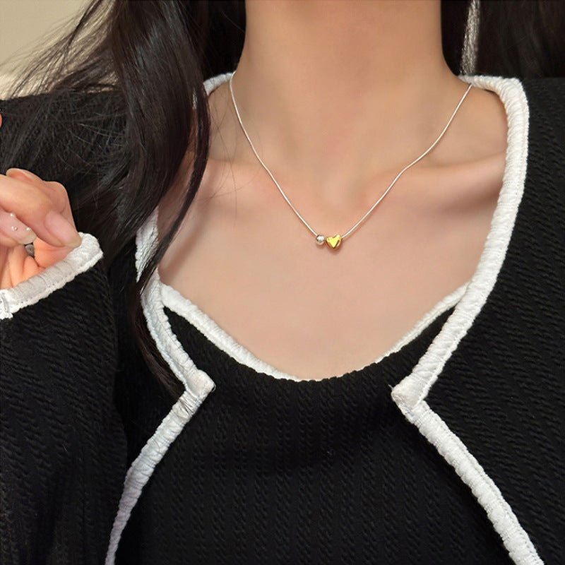 Necklace with a gold heart pendant worn by a person