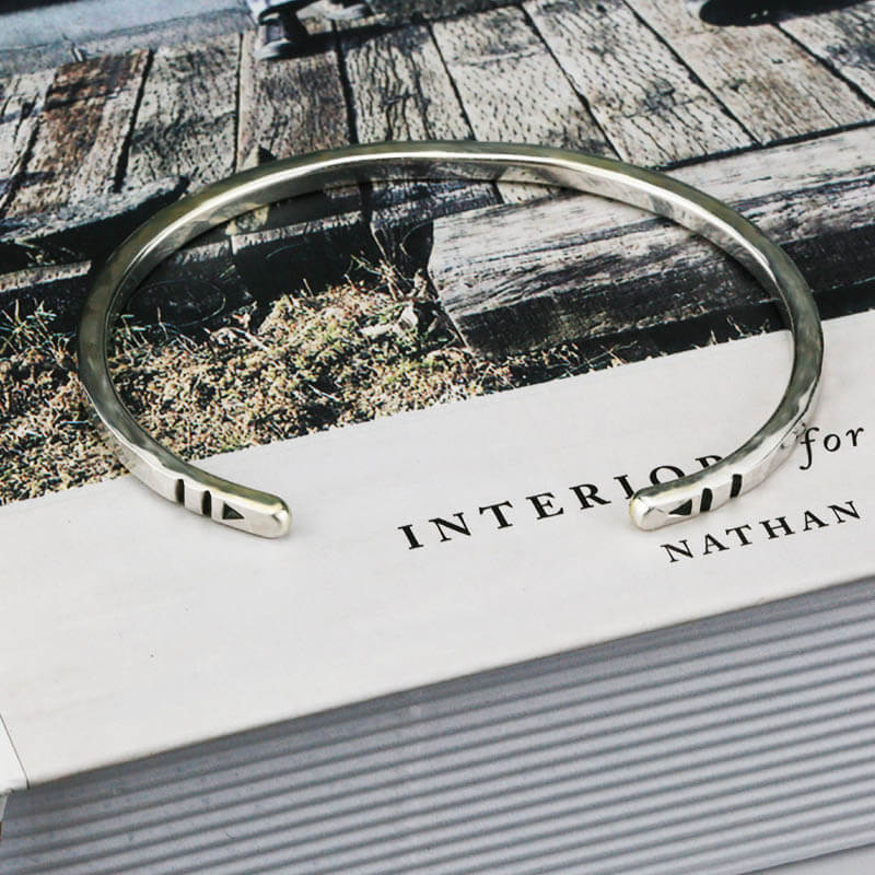 Silver bracelet on a book .