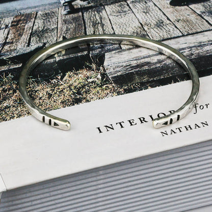 Silver bracelet on a book .