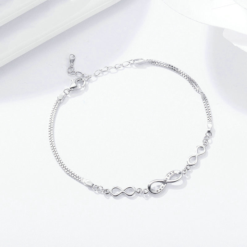 Silver anklet with infinity designs on a white background