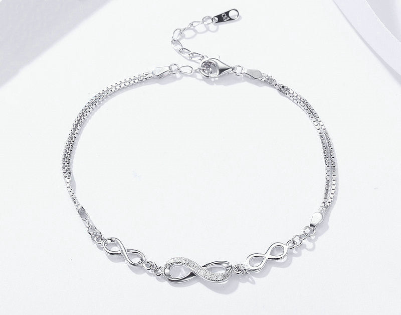 Silver bracelet with infinity symbol on a white background