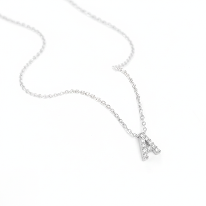 Silver necklace with a small letter 'A' pendant on a white background