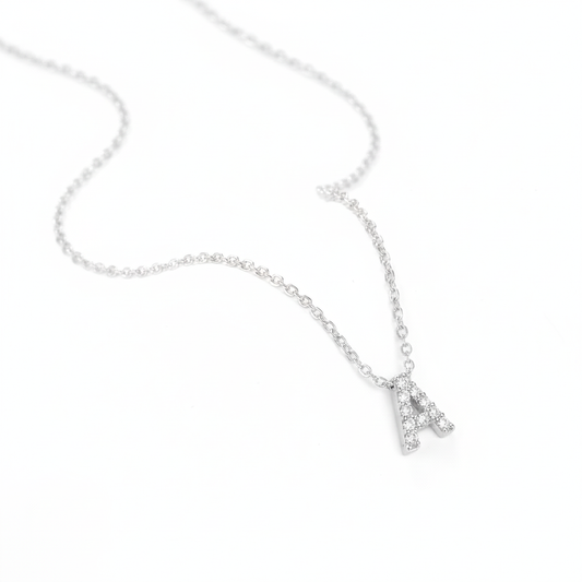 Silver necklace with a small letter 'A' pendant on a white background