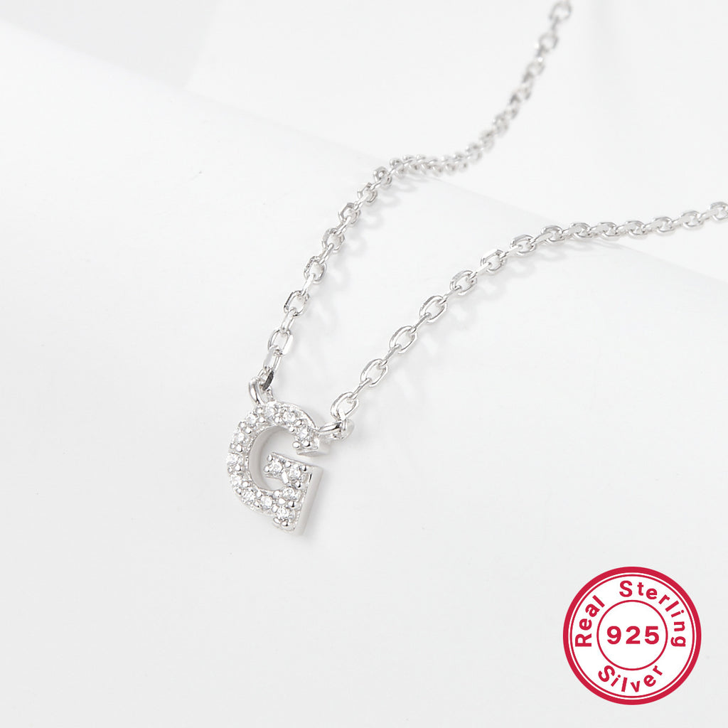 Silver necklace with a letter 'G' pendant on a white background, featuring a 'Real Sterling Silver 925' stamp.