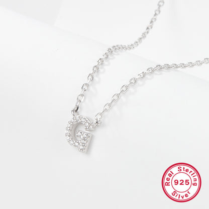 Silver necklace with a letter 'G' pendant on a white background, featuring a 'Real Sterling Silver 925' stamp.
