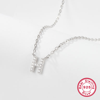 Silver necklace with a letter 'H' pendant on a white background, featuring a 'Real Sterling Silver 925' stamp.