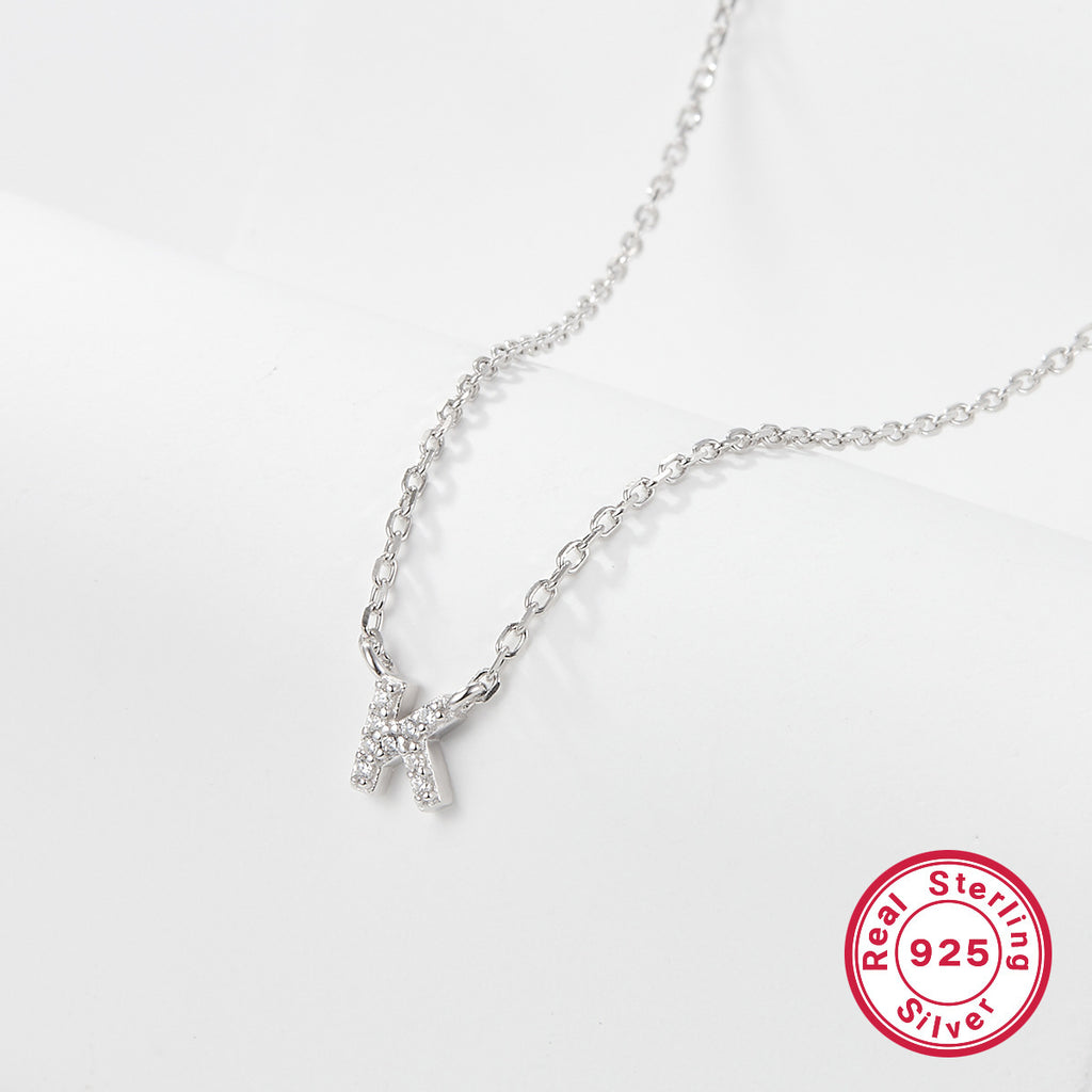 Silver necklace with a letter 'K' pendant on a white background, featuring a 'Real Sterling Silver 925' stamp.