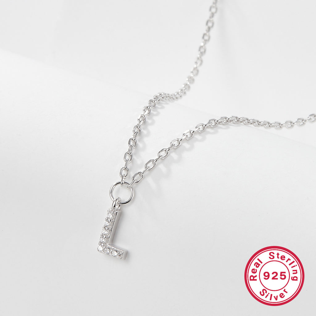 Silver necklace with a 'L' pendant on a light gray background, featuring a 'Real Sterling Silver 925' stamp.