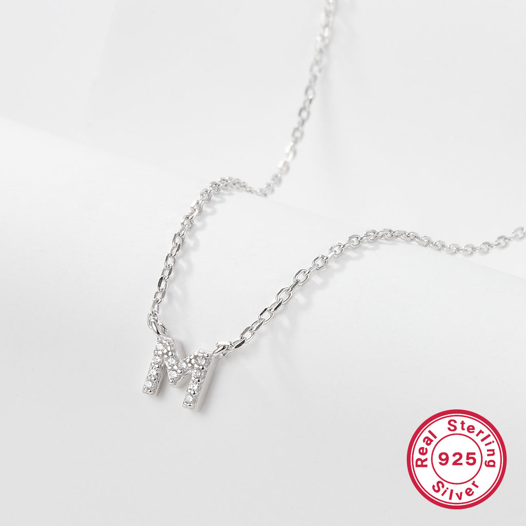 Silver necklace with a letter 'M' pendant on a white background, featuring a 'Real Sterling Silver 925' stamp.
