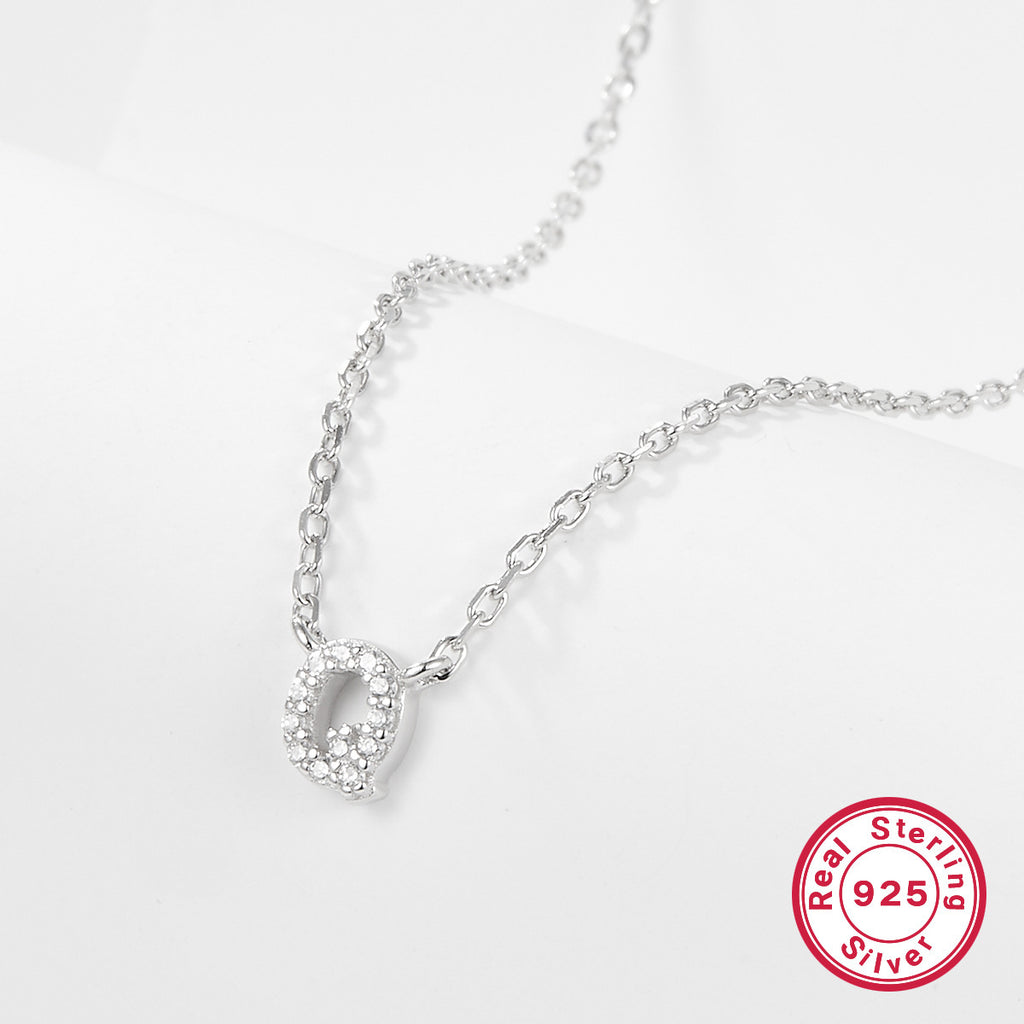 Silver necklace with a letter 'Q' pendant on a white background, featuring a 'Real Sterling Silver 925' stamp.