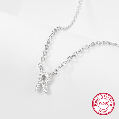 Silver necklace with a letter 'R' pendant on a white background, featuring a 'Real Sterling Silver 925' stamp.
