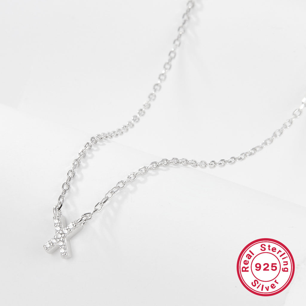 Silver necklace with a letter 'X' pendant on a white background, featuring a 'Real Sterling Silver 925' stamp.