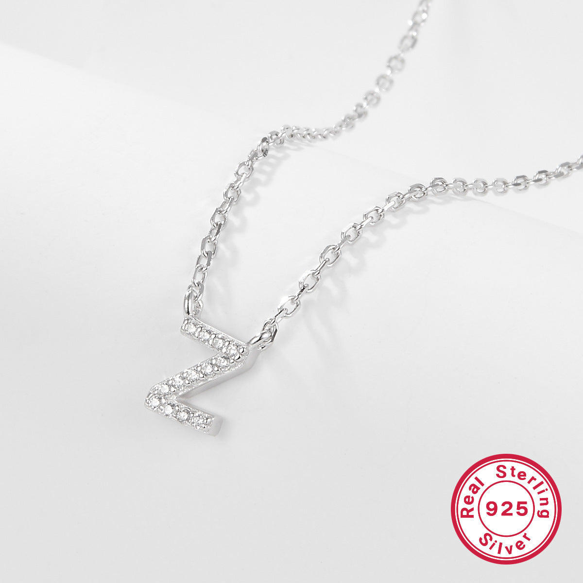 Silver necklace with a letter 'Z' pendant on a white background, featuring a 'Real Sterling Silver 925' stamp.