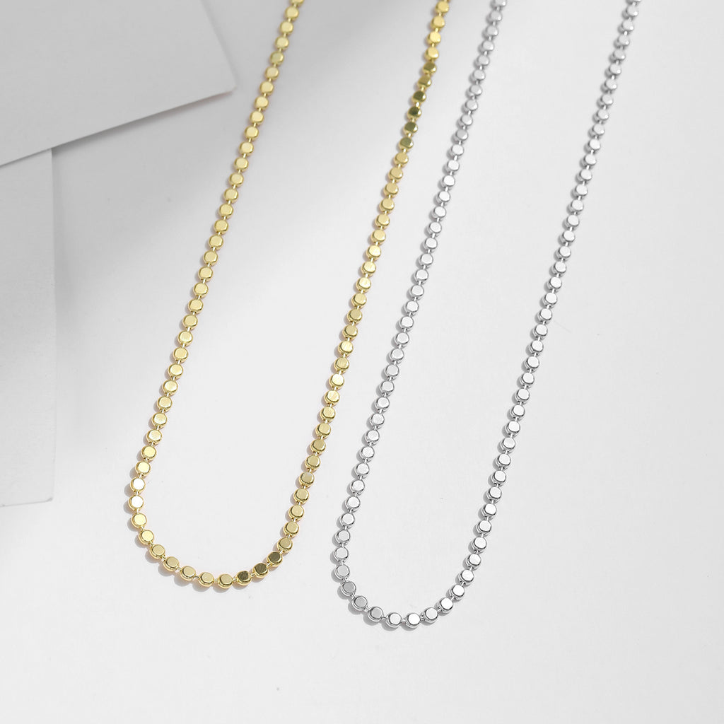 Two gold and silver chain necklaces on a white background