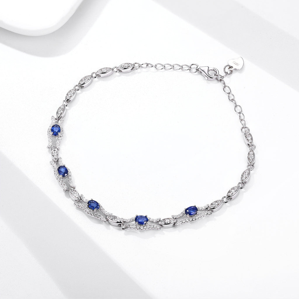 Silver bracelet with natural blue sapphire gemstones on a white background