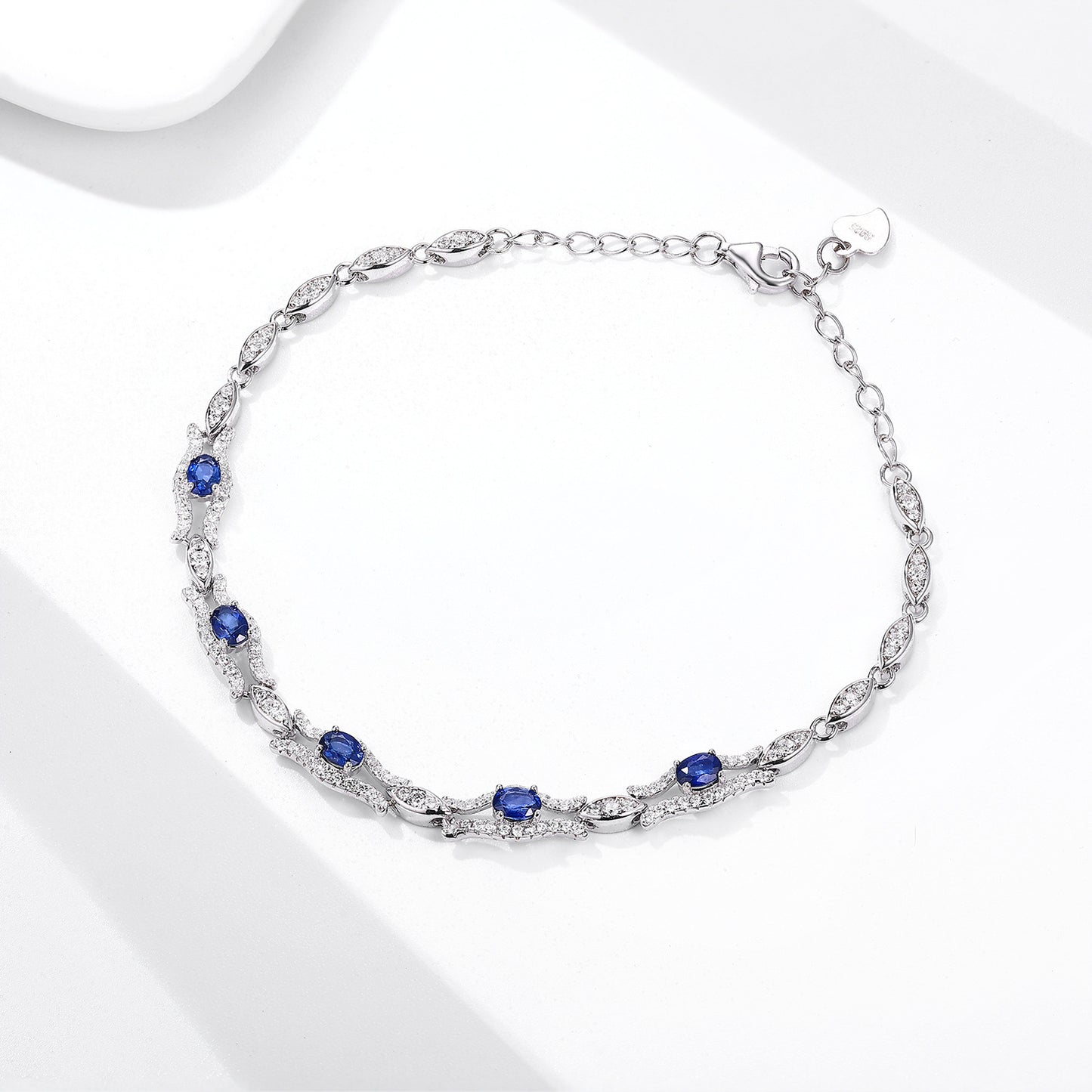 Silver bracelet with natural blue sapphire gemstones on a white background
