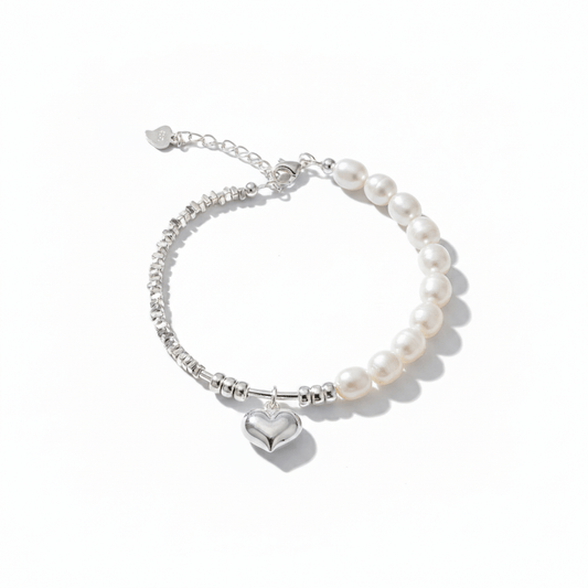 Pearl bracelet with a heart charm and silver beads on a white background