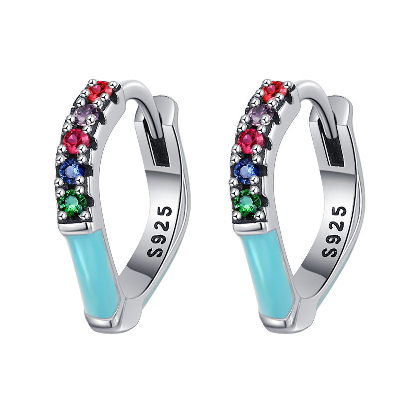 Pair of hoop earrings with colorful gemstones and light blue enamel on a white background