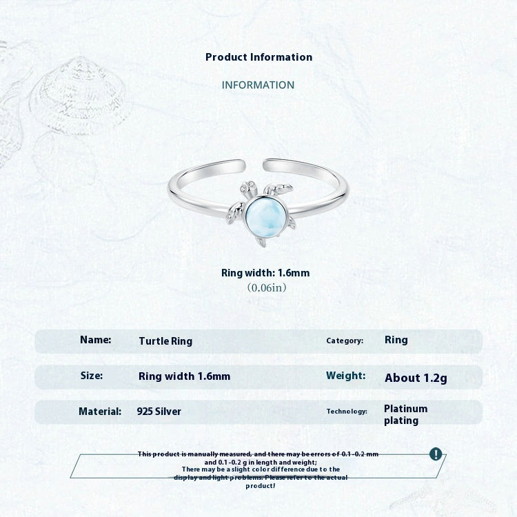 Turtle ring with a gemstone on a white background, featuring product information.