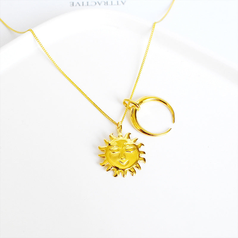 Gold necklace with sun and moon pendants on a white background