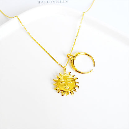 Gold necklace with sun and moon pendants on a white background