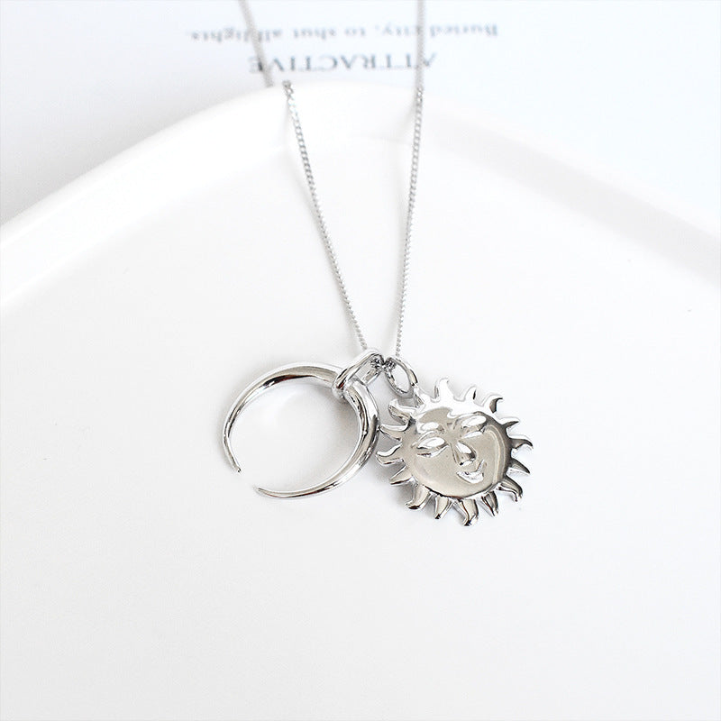 Silver necklace with a sun and moon pendant on a white background