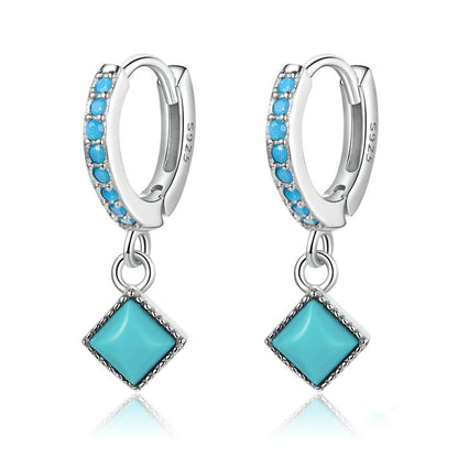 Silver hoop earrings with turquoise stones on a white background