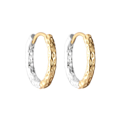 Two tone gold and silver hoop earrings with textured design on a white background