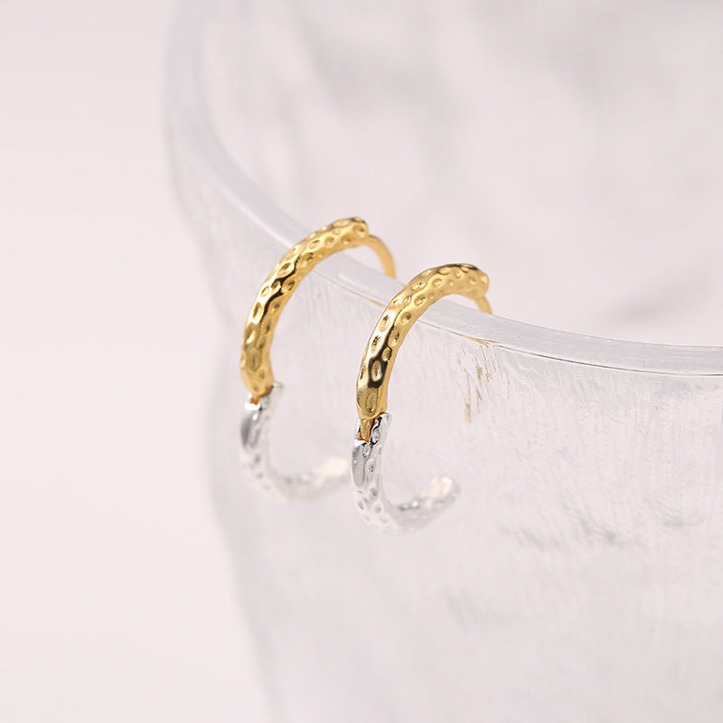 Gold and silver hoop earrings on a white background