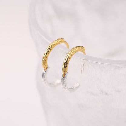 Gold and silver hoop earrings on a white background