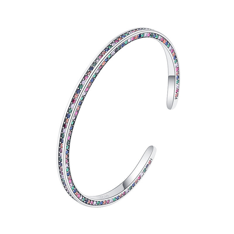 Silver bangle with multicolored stones on a white background