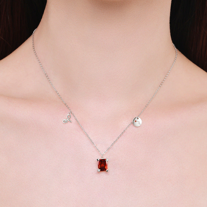 Necklace with a red gemstone pendant on a person's neck