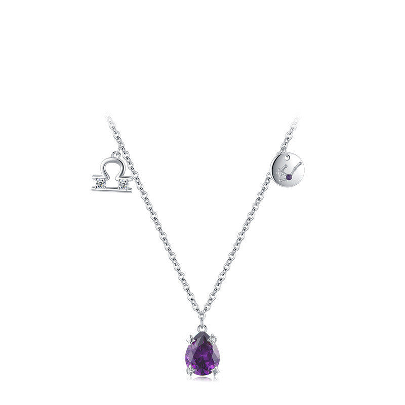 Silver necklace with a purple teardrop pendant on a white background
