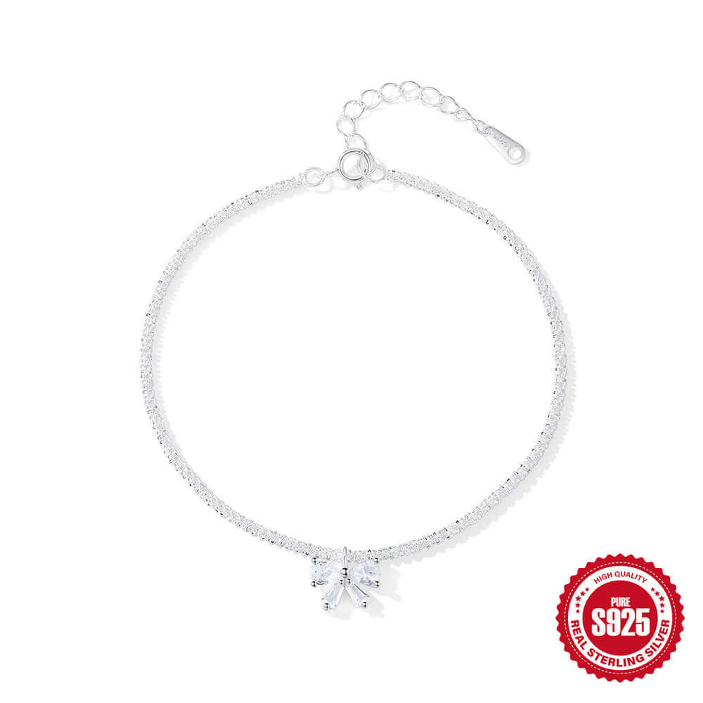 Silver bracelet with a bow shaped gemstone on a white background, featuring a '925 sterling silver' stamp.
