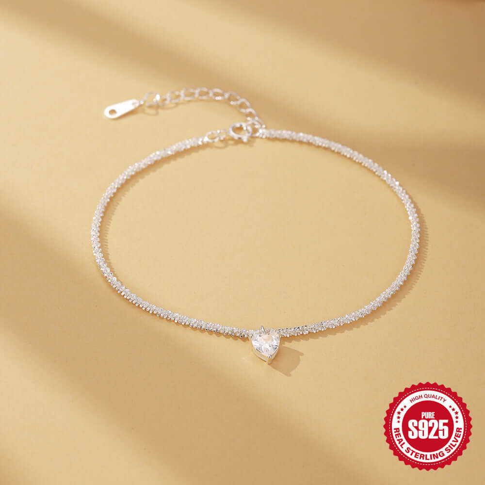 Silver necklace with a heart-shaped pendant on a beige background, featuring a '925 Sterling Silver' stamp.