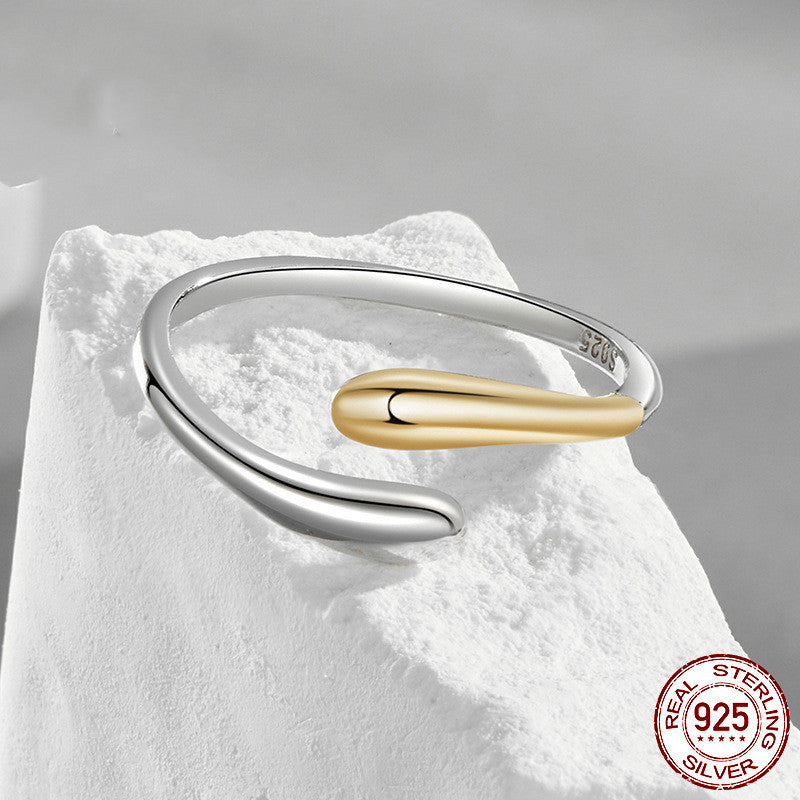 Silver and gold ring on a white stone surface with 'Real Sterling Silver 925' stamp.