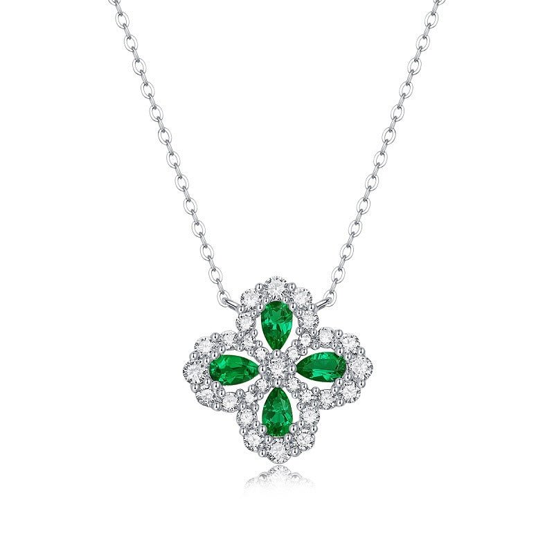 Silver necklace with a green emerald gemstone pendant on a white background
