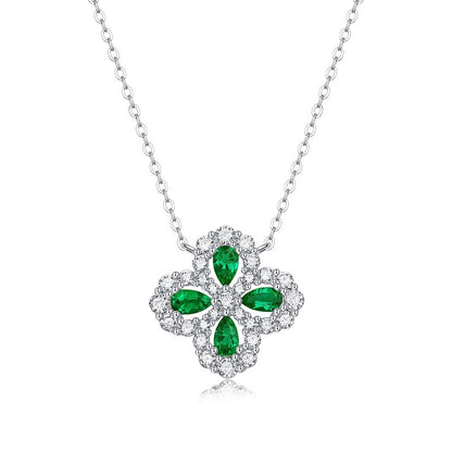 Silver necklace with a green emerald gemstone pendant on a white background