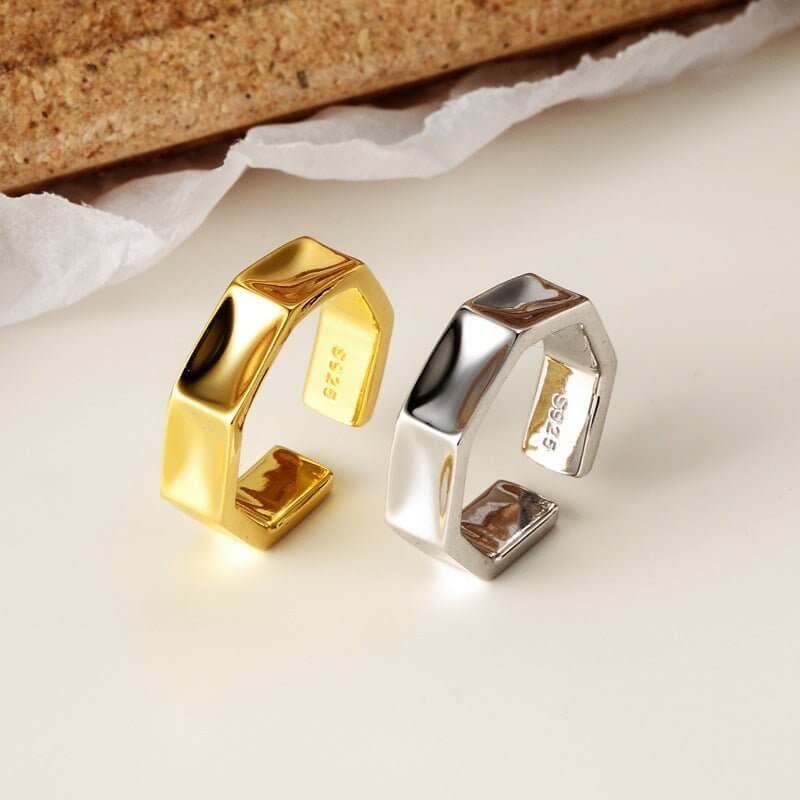 Gold and silver geometric ring on a light background