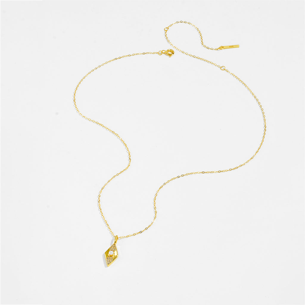 Gold color necklace with a pendant on a white background.