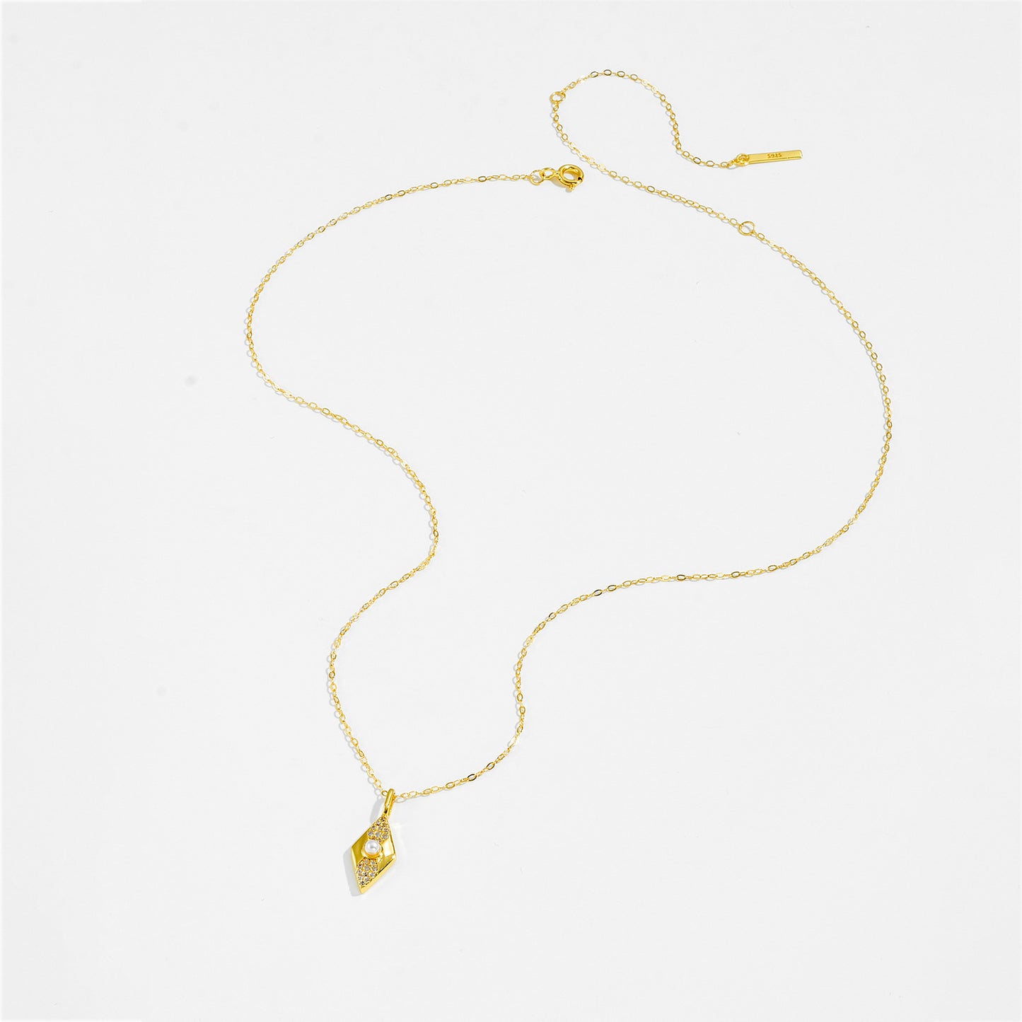 Gold color necklace with a pendant on a white background.