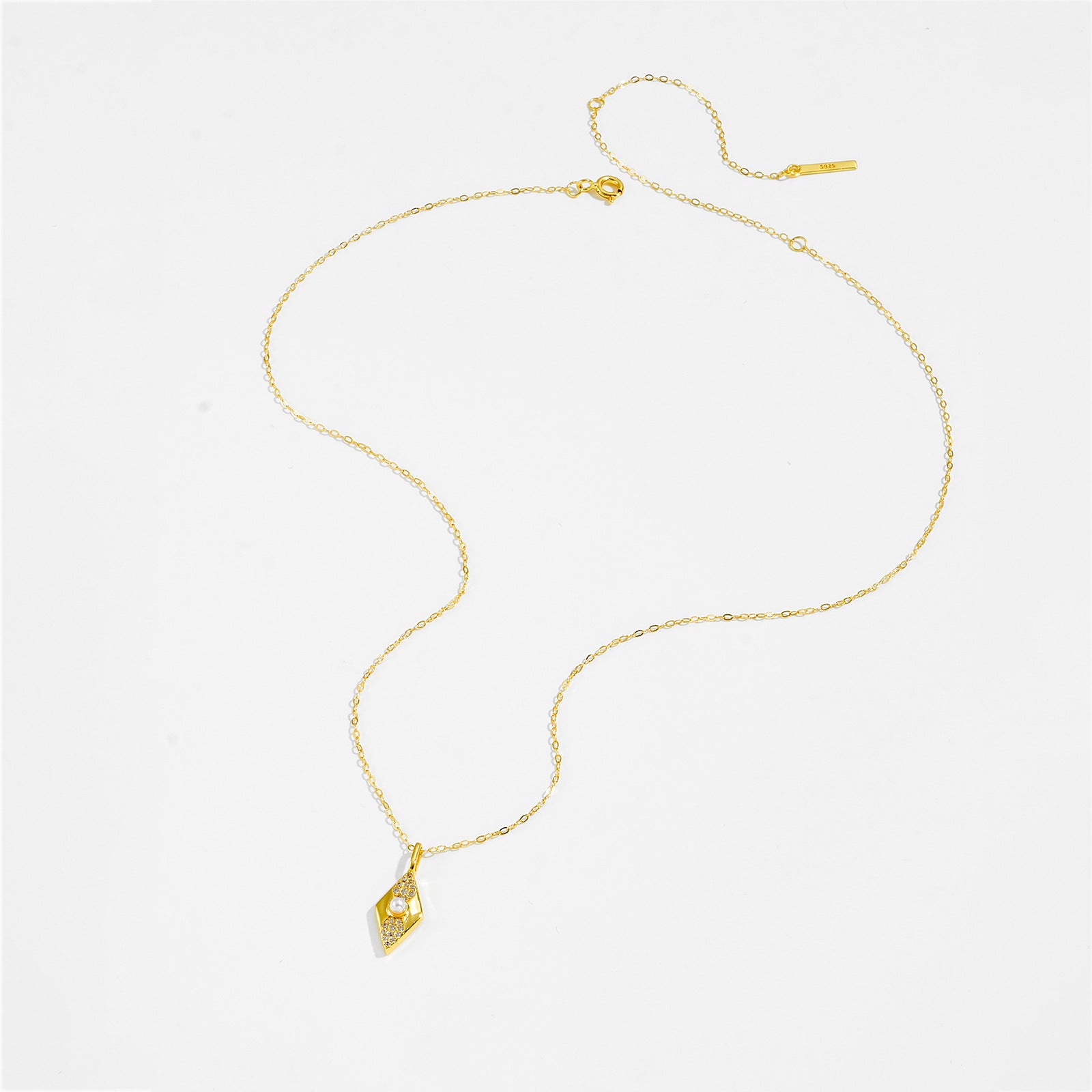 Gold color necklace with a pendant on a white background.