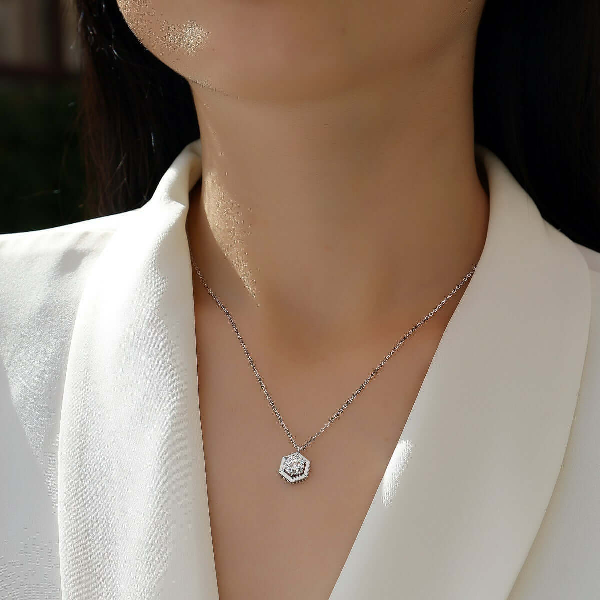 The Moissanite Geometric Necklace worn to show its size and elegant appearance against a person's white collared jacket
