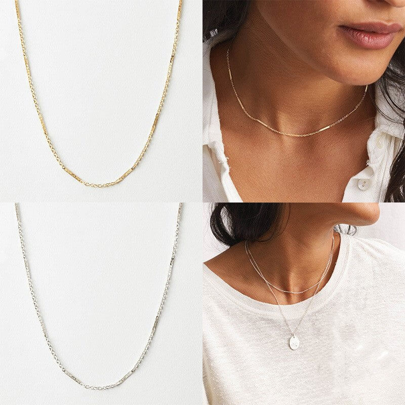 Two necklaces, one gold and one silver, worn by a person on a white background.