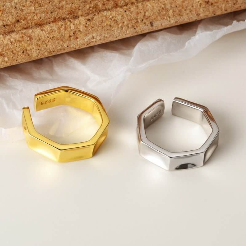 Gold and silver geometric rings on a light background